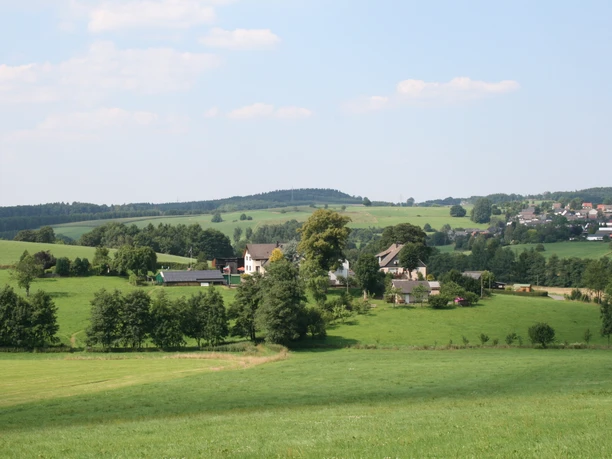 Landschaft - Blick vom Padberg Blick in die Ferne. Man sieht Wiesen, Bäume und Häuser in der Landschaft.