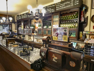 Weinhaus Vogel Holzgetäfelte Kneipe mit langer Theke, Gläsern und Regalen voller Wein- und Bierflaschen