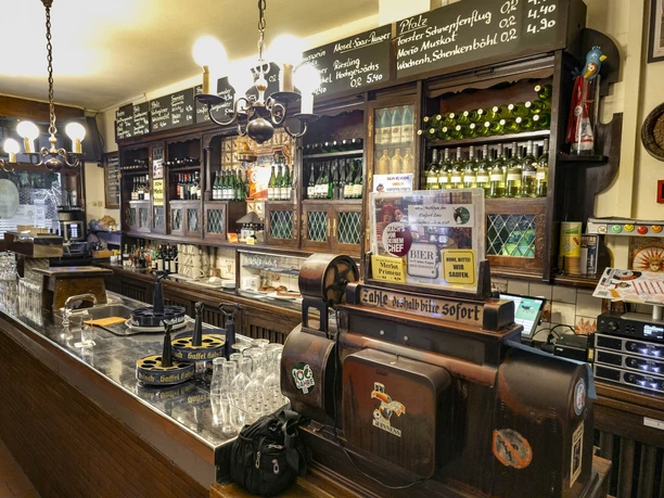 Weinhaus Vogel Holzgetäfelte Kneipe mit langer Theke, Gläsern und Regalen voller Wein- und Bierflaschen