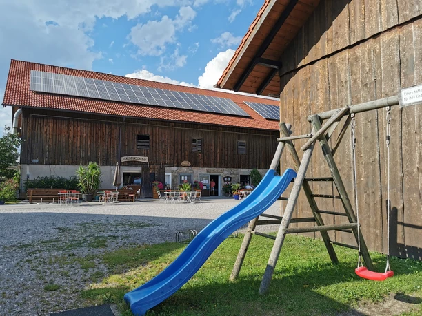 Museumcafe Holzhaus mit Café und Spielplatz mit Rutsche und Schaukel für eine beliebte Pause.
