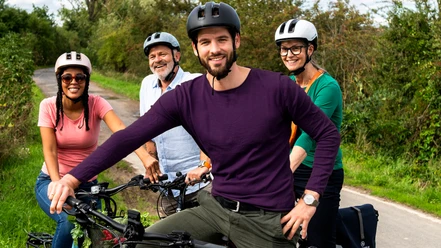 STADTRADELN_(c)Klima-Bündnis Felix Krammer_ (6).jpg Vier Radfahrende mit Helmen auf einem Weg in grüner Landschaft während einer gemeinsamen Tour.