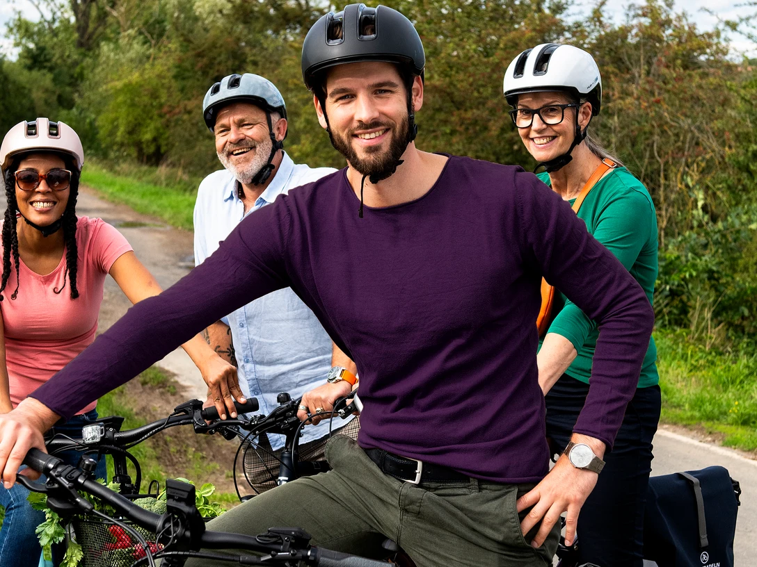 STADTRADELN_(c)Klima-Bündnis Felix Krammer_ (6).jpg Vier Radfahrende mit Helmen auf einem Weg in grüner Landschaft während einer gemeinsamen Tour.