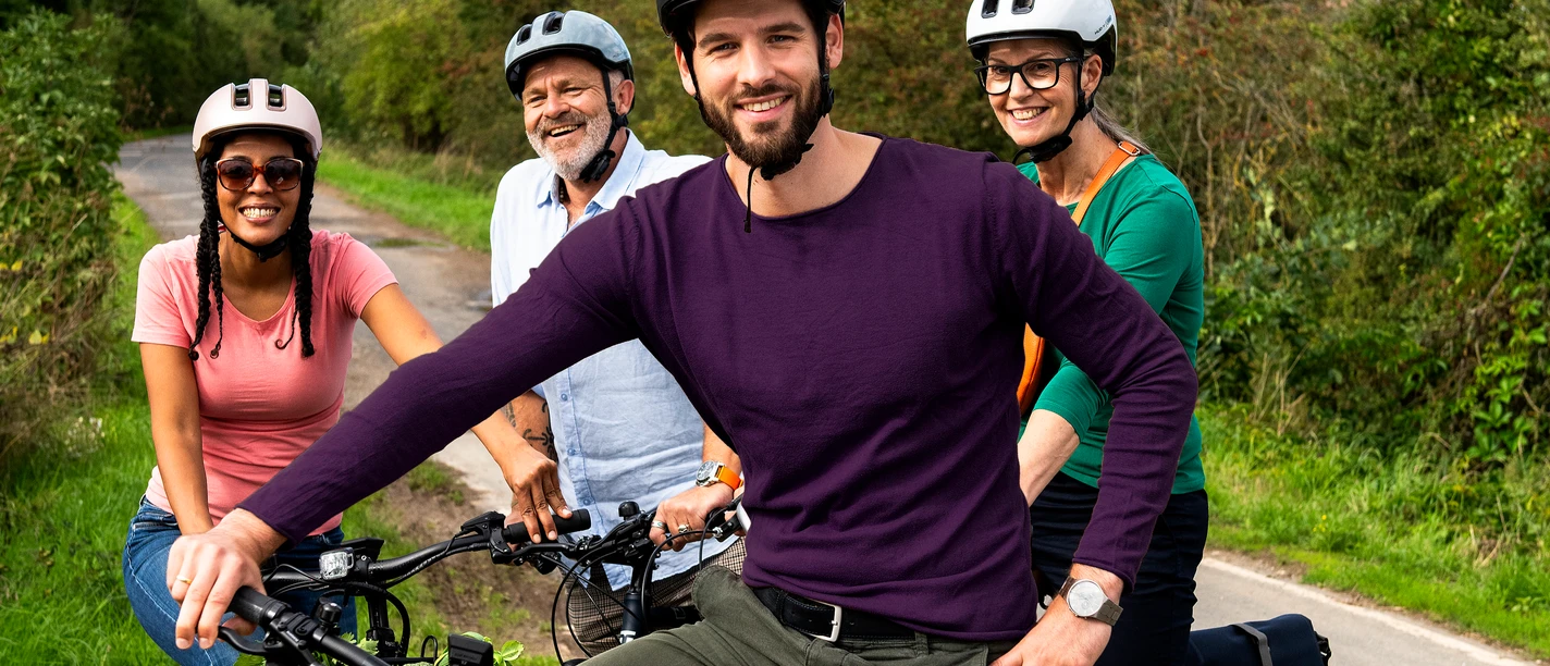 STADTRADELN_(c)Klima-Bündnis Felix Krammer_ (6).jpg Vier Radfahrende mit Helmen auf einem Weg in grüner Landschaft während einer gemeinsamen Tour.