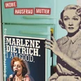 Vintage Collage mit retro Frauengrafik, Textstreifen und Bühnenposter an einem Kühlschrank.