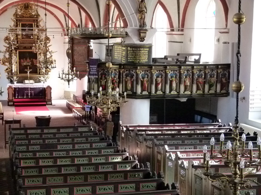 St. Severi Kirche Otterndorf Innenraum der Kirche St. Severi in Otterndorf mit reich verziertem Altar und kunstvoll bemalten Emporen.
