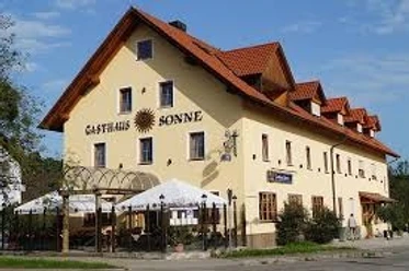 Gasthof Sonne.jpg Großes gelbes Gasthaus mit rotem Dach und hellem Biergarten vor dem Haus.
