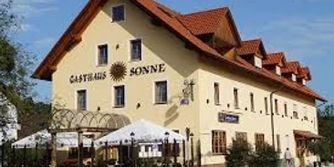 Gasthof Sonne.jpg Großes gelbes Gasthaus mit rotem Dach und hellem Biergarten vor dem Haus.