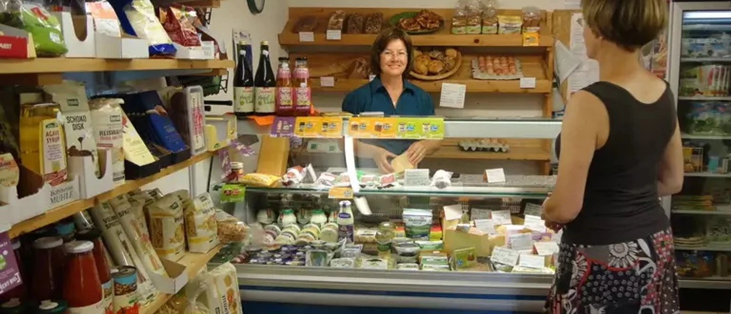 Hofladen beim Hias Eine Verkäuferin bietet viele regionale Waren im kleinen Laden an.