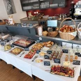 Cafe Hausen Frühstücksbuffet mit Brot, Obst, Käse und vielen kleinen Gläsern mit Speisen.