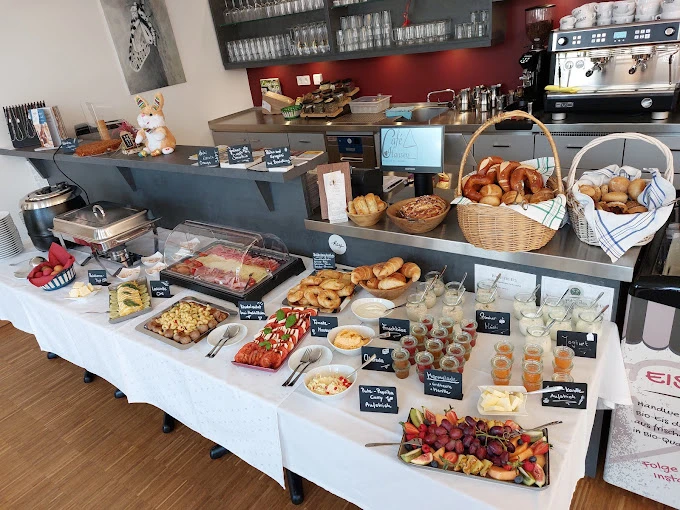 Cafe Hausen Frühstücksbuffet mit Brot, Obst, Käse und vielen kleinen Gläsern mit Speisen.