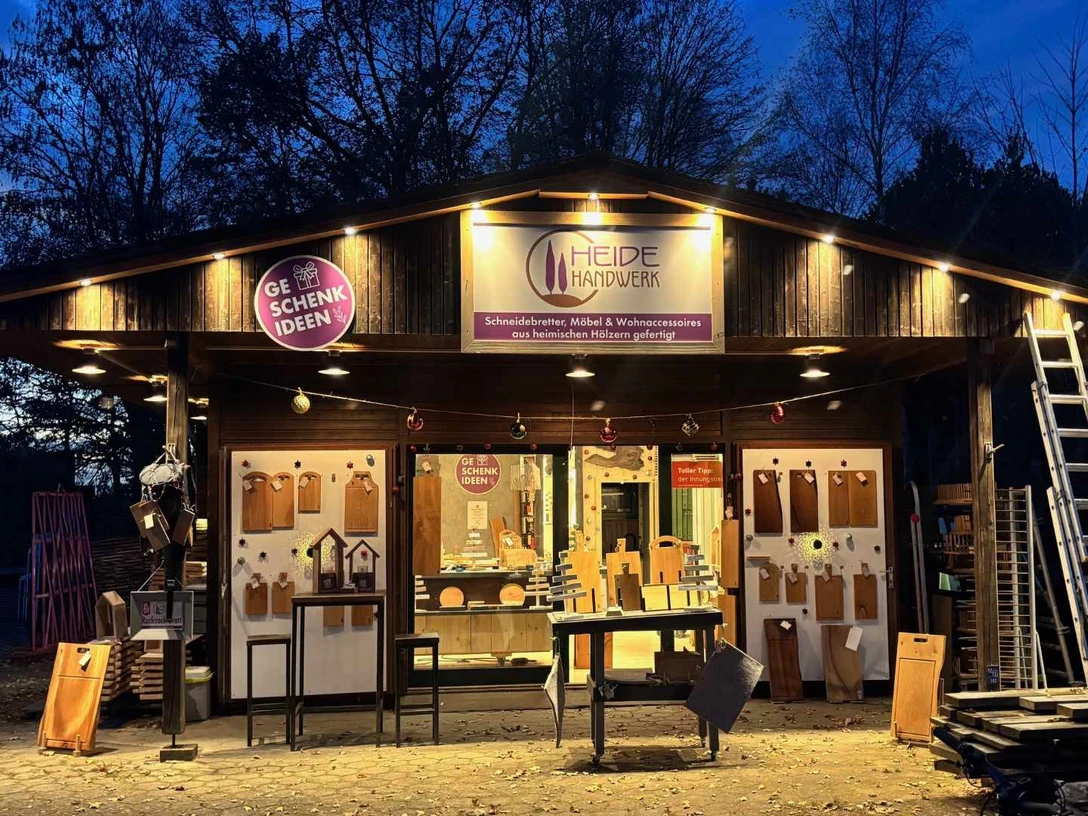 HeideHandwerk-Behringen.jpg Holzladen bei Abenddämmerung mit Schneidebrettern und Wohnaccessoires aus regionalem Handwerk