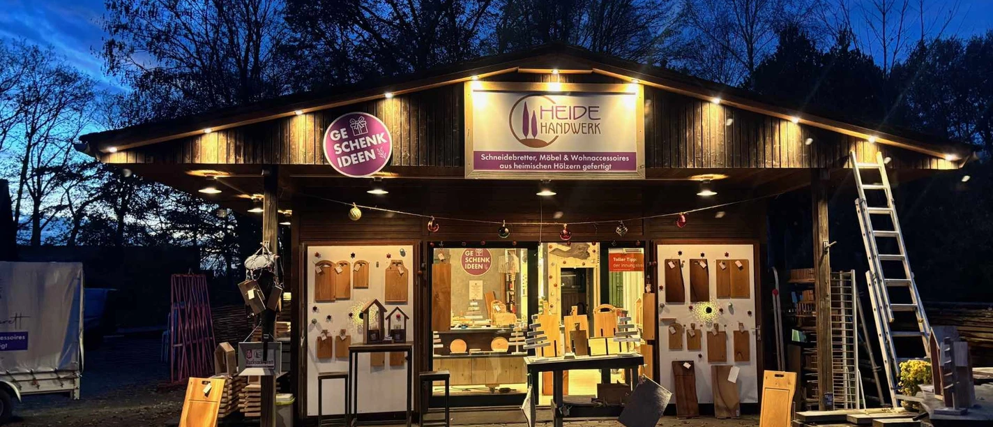HeideHandwerk-Behringen.jpg Holzladen bei Abenddämmerung mit Schneidebrettern und Wohnaccessoires aus regionalem Handwerk
