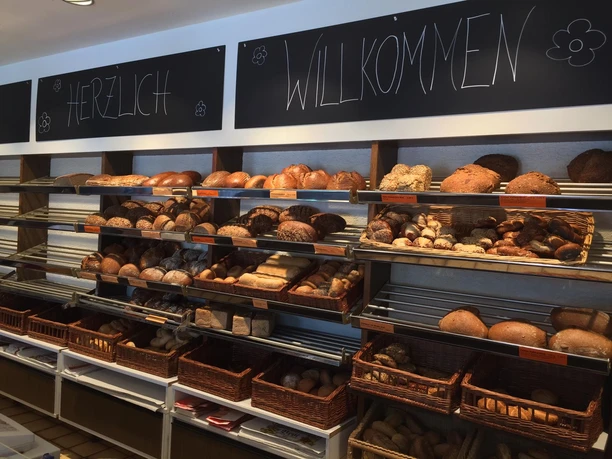 Bäckerei Sesar Viele frische Brote liegen in Regalen und wirken einladend für Gäste.