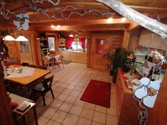 Schneidlbergstuben Heller Raum mit Holzmöbeln und Tischen. Große Fenster geben viel Licht.