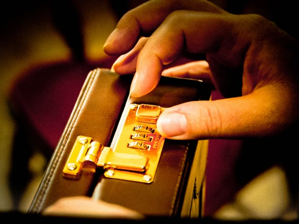 2 Escape IMG_0608 (c) Marita Fischer_Erlebnis Bremerhaven.jpg Nahaufnahme einer Hand, die an einem Zahlenschloss eines braunen Aktenkoffers dreht.