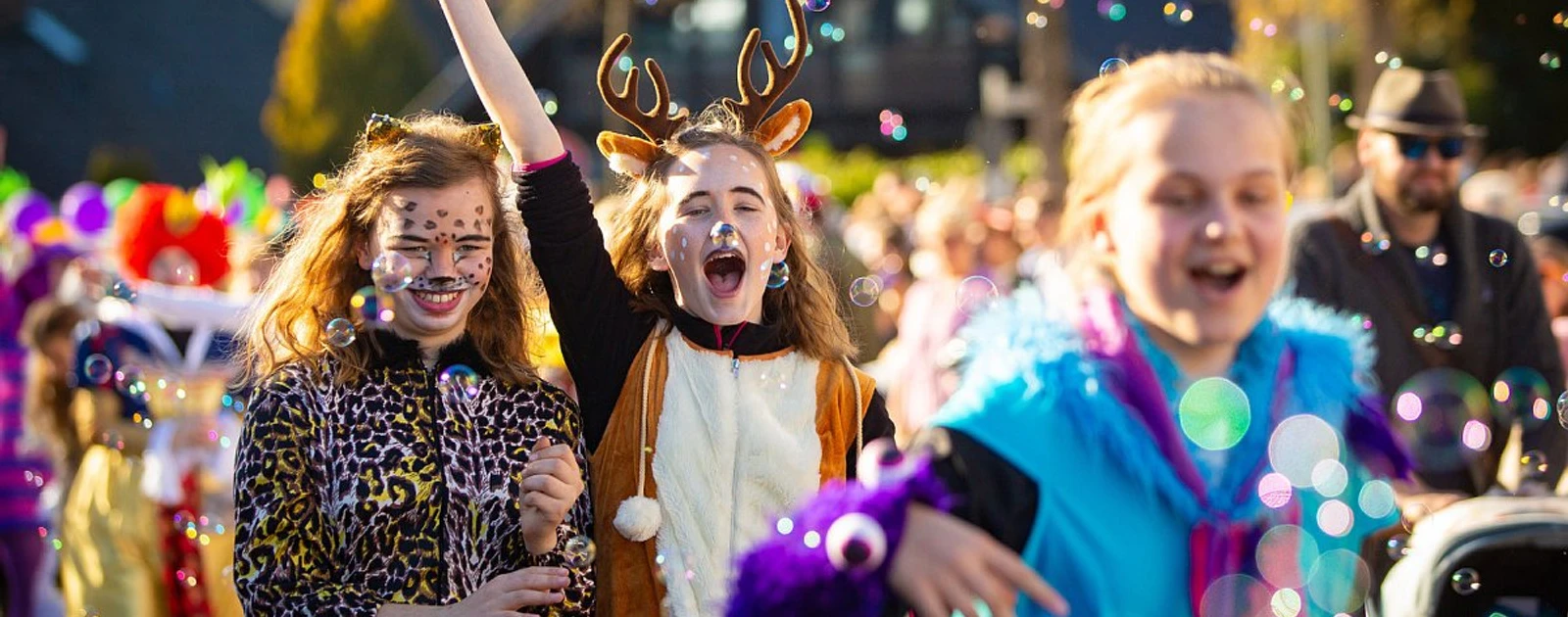 Achtung 3 - 2026.jpg Kinder in bunten Kostümen feiern zwischen Seifenblasen auf einem Karnevalsumzug