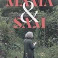 Book cover "Mama & Sam" Person with gray hair reads in an overgrown garden, surrounded by flowers and greenery