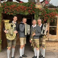 Hinterberger-Musikanten-2026.jpg Vier Hinterberger Musikanten in Tracht vor festlicher Almhütte