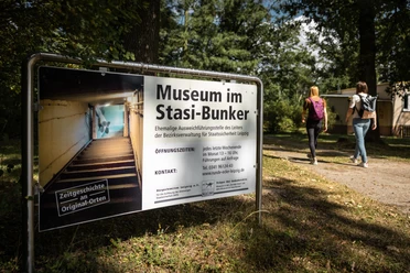 Stasi-Bunker - Museum in der Region Leipzig Eingangsschild des Stasi-Bunkers in Machern vor einem bewaldeten Hintergrund.