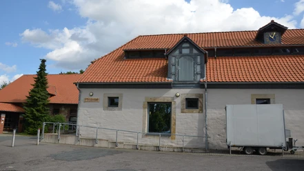 Pferdestall (3)_aussen_HD_16zu9.JPG Ehemaliger Pferdestall mit rotem Ziegeldach, heller Fassade und barrierefreier Rampe vor dem Eingang.