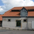 Pferdestall (3)_aussen_HD_16zu9.JPG Ehemaliger Pferdestall mit rotem Ziegeldach, heller Fassade und barrierefreier Rampe vor dem Eingang.