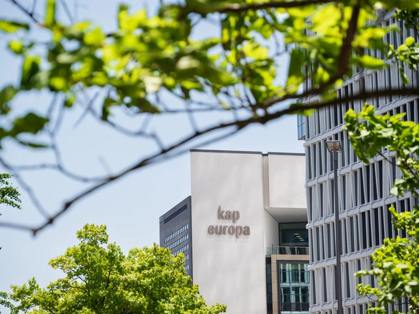 Kap Europa Messe Frankfurt - Aussenansicht Blick durch grüne Baumkronen auf das Kap Europa in Frankfurt.