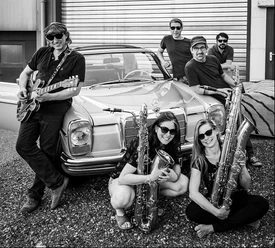 The-Voodoohounds.jpg Musikergruppe vor Oldtimer in lebendiger Szene