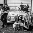 The-Voodoohounds.jpg Musikergruppe vor Oldtimer in lebendiger Szene