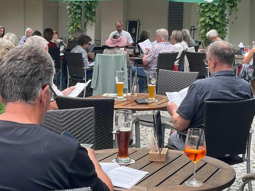 Offenes-Singen-Brunnenhof.jpg Offenes Singen im Bunnenof mit Gästen an Tischen