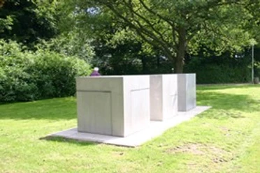 Skulpturen - Drei- Phasen Würfel Moderne Würfelskulptur aus Metall auf einer Grünfläche unter Bäumen in Otterndorf.