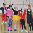 Kinderkarneval in der Kleinen Halle Feldbreite Fünf kostümierte Kinder und Jugendliche posieren fröhlich auf einer Turnleiter beim Kinderkarneval.