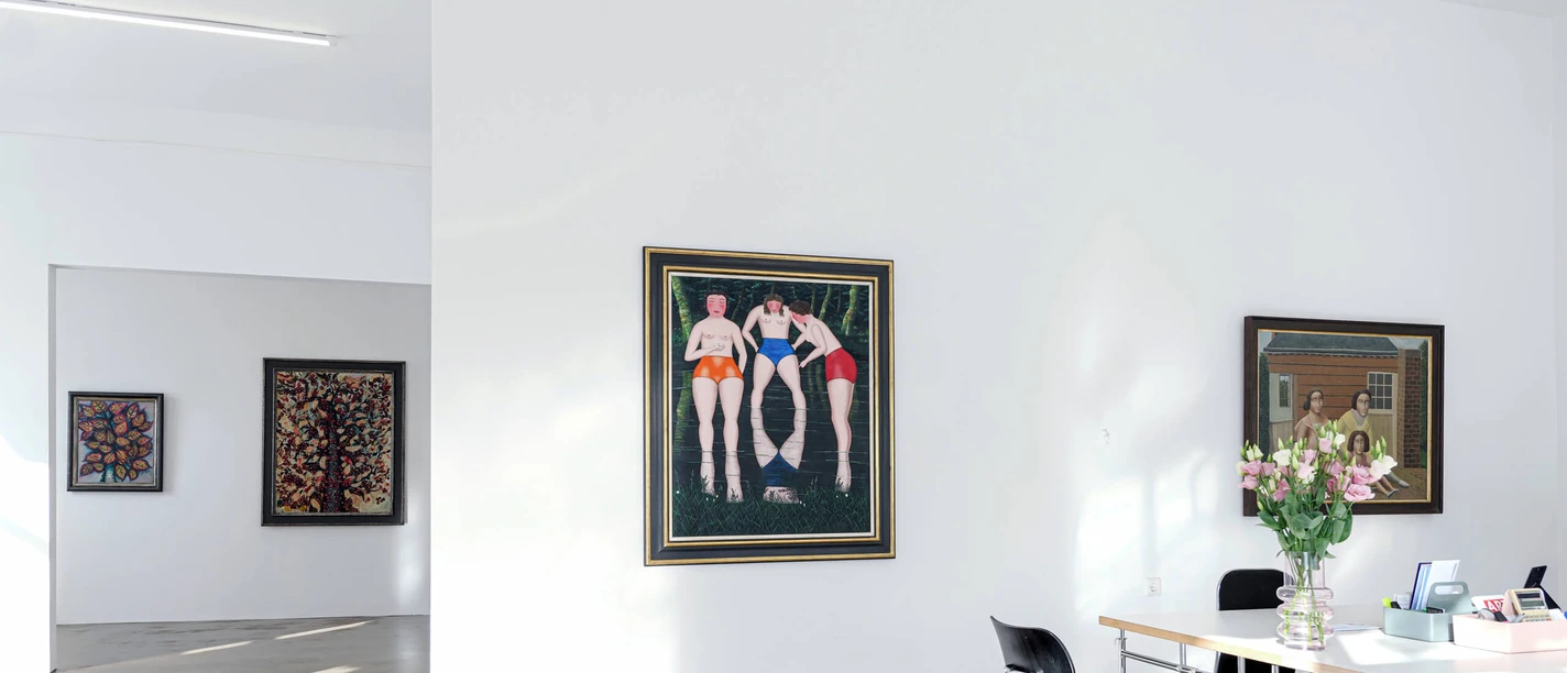 Sammlung Zander Köln Heller Galerieraum mit Gemälden, Arbeitstisch mit Blumen und ruhendem Hund am Boden.