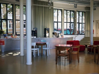 Filmhaus, Foyer Ein helles Foyer mit großer Fensterfront und Säulen. A bright foyer with a large window front and columns.