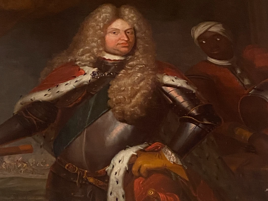 LAK: Georg Albrecht von Ostfriesland Erzähltheater Gemälde eines adligen Mannes in Rüstung mit rotem Mantel und weißem Hermelinbesatz, daneben ein Diener.