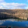 Märchenhaftes Waldbaden am Kalkwald Schlupkothen und der Blauen Lagune - Anja Lindemann Blick auf den Steinbruch Schlupkothen in Wülfrath, umgeben von Kalkfelsen und kahlen Bäumen, der Himmel spiegelt sich im Wasser.