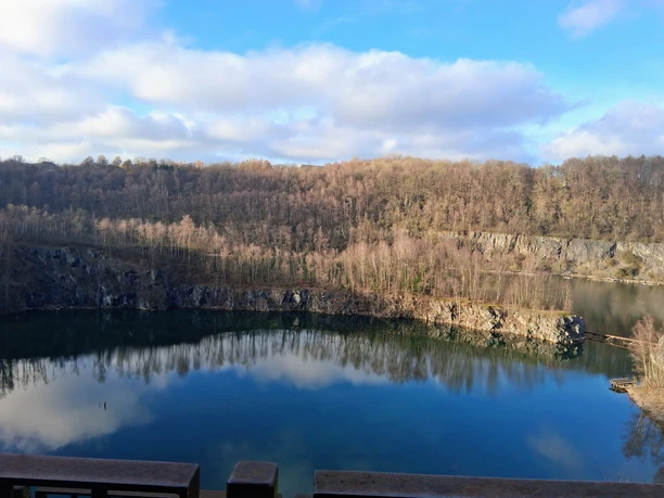 Märchenhaftes Waldbaden am Kalkwald Schlupkothen und der Blauen Lagune - Anja Lindemann Blick auf den Steinbruch Schlupkothen in Wülfrath, umgeben von Kalkfelsen und kahlen Bäumen, der Himmel spiegelt sich im Wasser.
