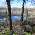 Märchenhaftes Waldbaden am Kalkwald Schlupkothen und der Blauen Lagune - Anja Lindemann Blick auf den Steinbruch Schlupkothen in Wülfrath, umrahmt von kahlen Bäumen und moosbewachsenen Felsen.