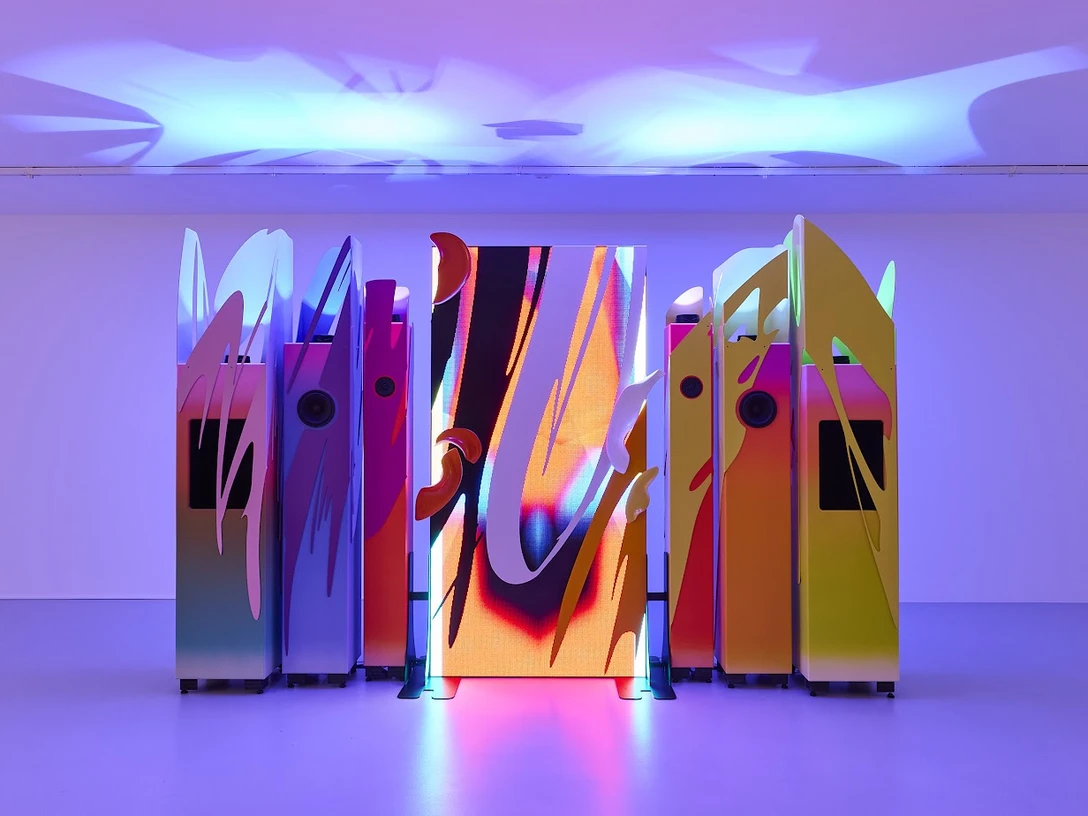 Márton Nemes, Toccata, 2025 Farbintensive Installation mit leuchtenden Paneelen und futuristischen Formen in dynamischem Licht.