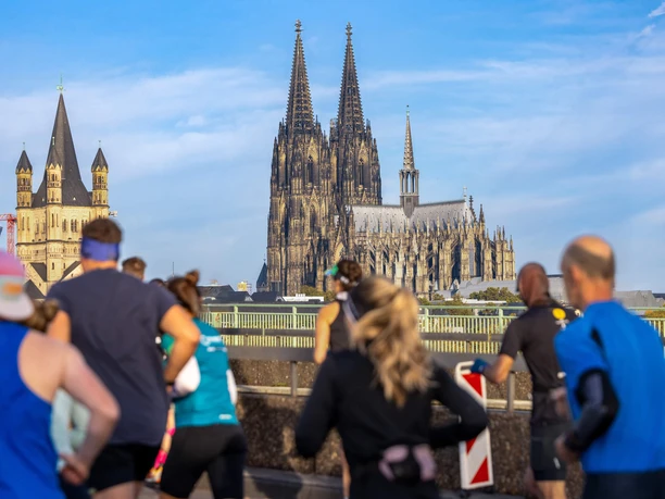 Köln Marathon Runners pass in front of Cologne Cathedral, creating an energetic marathon backdrop.