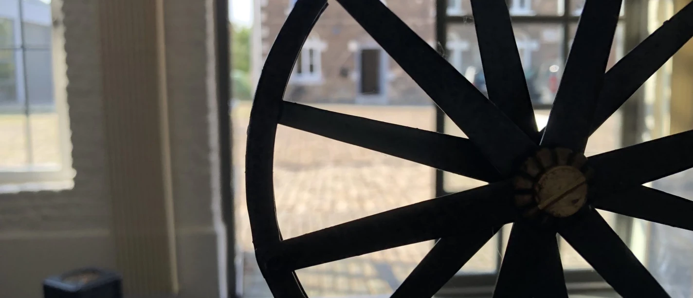 Museum Zinkhütter Hof (c) Museum Zinkhütter Hof e.V..jpg Im Vordergrund ist ein altes Rad ausgestellt. Dahinter erkennt man den Eingang des Museums und einen gepflasterten Vorplatz.