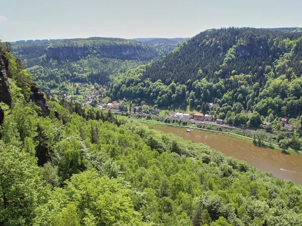 Belvedere Hrensko Aussicht auf die Elbe Blick auf ein grünes Tal mit Fluss, umgeben von bewaldeten Hügeln und Felsen.