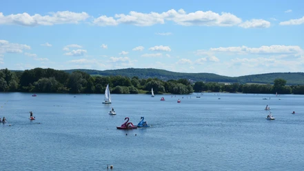 Ausblick Salzgittersee mit Höhenzug (7)_HD_16zu9.JPG Segel- und Tretboote auf dem Salzgittersee mit grünem Höhenzug und blauem Himmel im Hintergrund