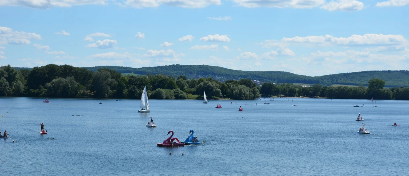 Ausblick Salzgittersee mit Höhenzug (7)_HD_16zu9.JPG Segel- und Tretboote auf dem Salzgittersee mit grünem Höhenzug und blauem Himmel im Hintergrund
