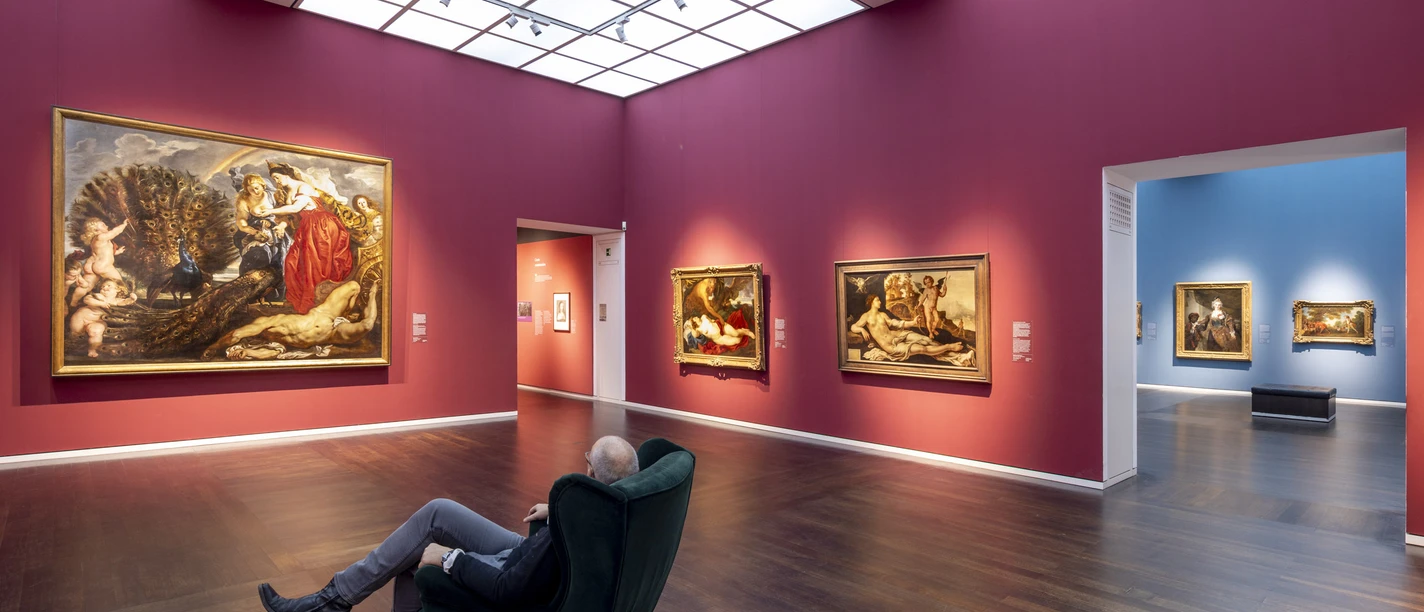 Wallraf-Richartz-Museum Gallery with large-format paintings and a seated person in front of colorful walls.