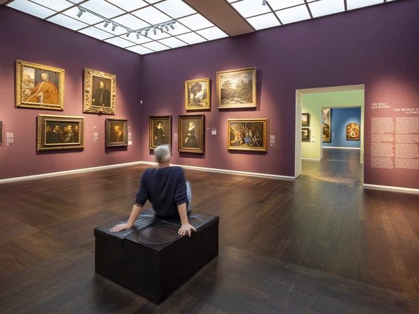 Wallraf-Richartz Museum Exhibition room with paintings on purple walls and a person sitting on a bench
