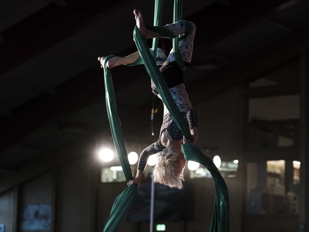 Acrobatics on the green cloth A child hangs upside down wrapped in a green vertical cloth during an exercise in the Aletsch Arena hands-on circus.