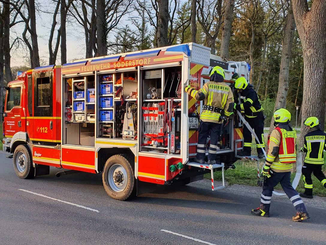 Feuerwehr Soderstorf.jpg Feuerwehrleute bereiten Einsatz am roten Löschfahrzeug der Freiwilligen Feuerwehr Soderstorf vor.
