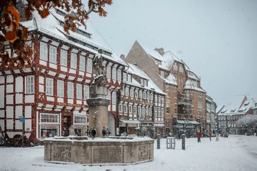 Einbecker Marktplatz im Winter Marktplatz mit Brunnen umringt von Fachwerk Häusern im Schnee