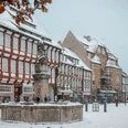 Einbecker Marktplatz im Winter Marktplatz mit Brunnen umringt von Fachwerk Häusern im Schnee
