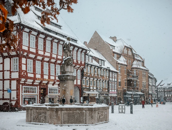 Einbecker Marktplatz im Winter Marktplatz mit Brunnen umringt von Fachwerk Häusern im Schnee
